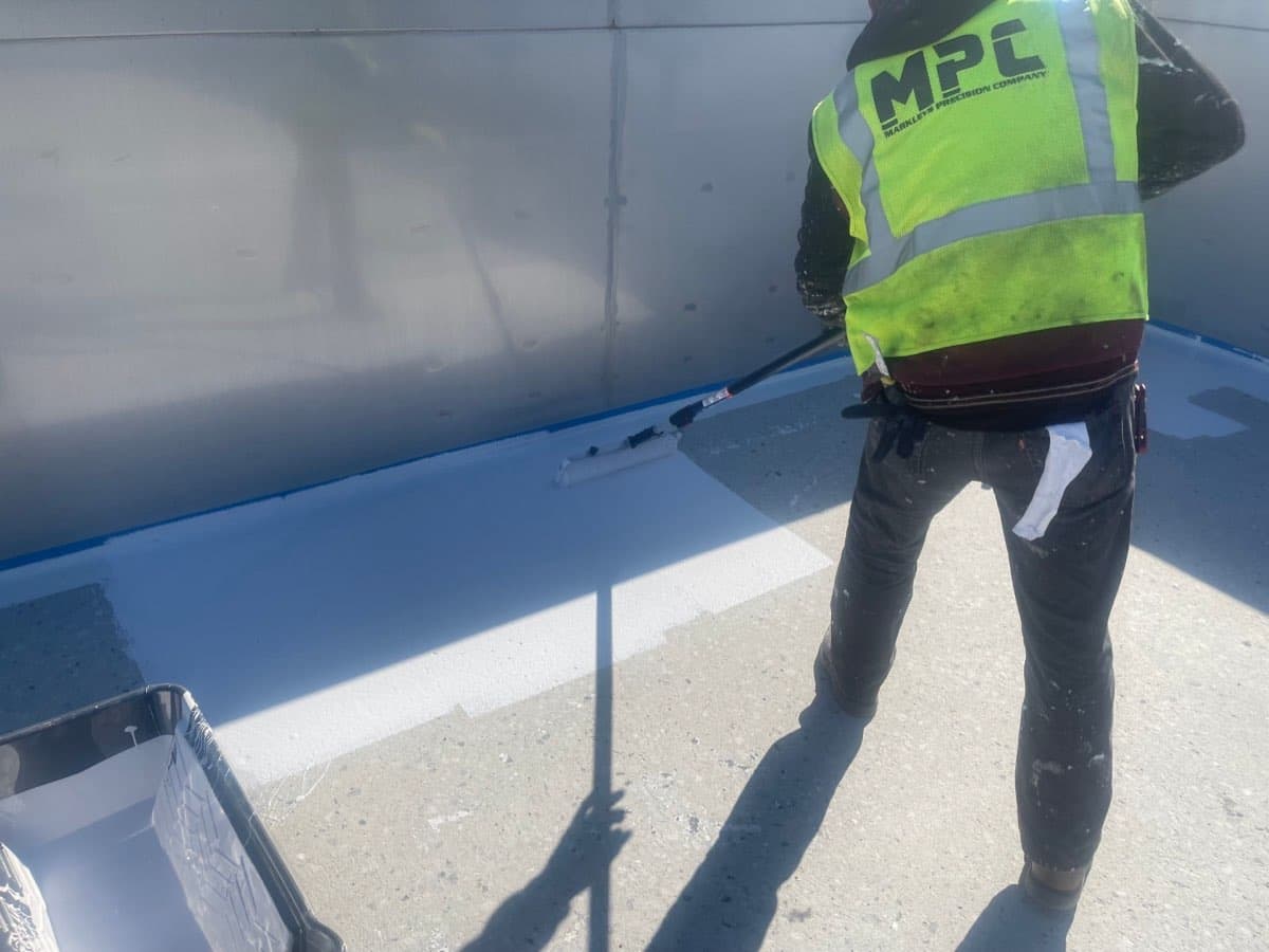 MPC worker applying pool coating at commercial pool facility