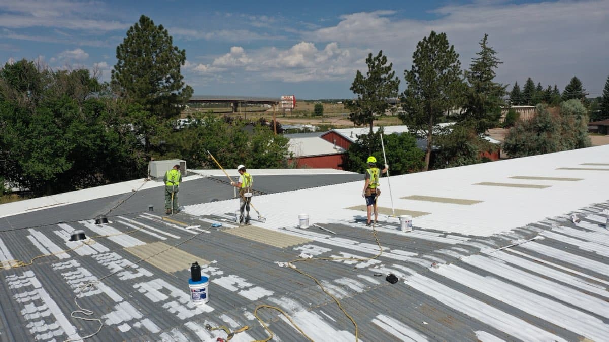 MPC crew applying roof coating on large commercial building