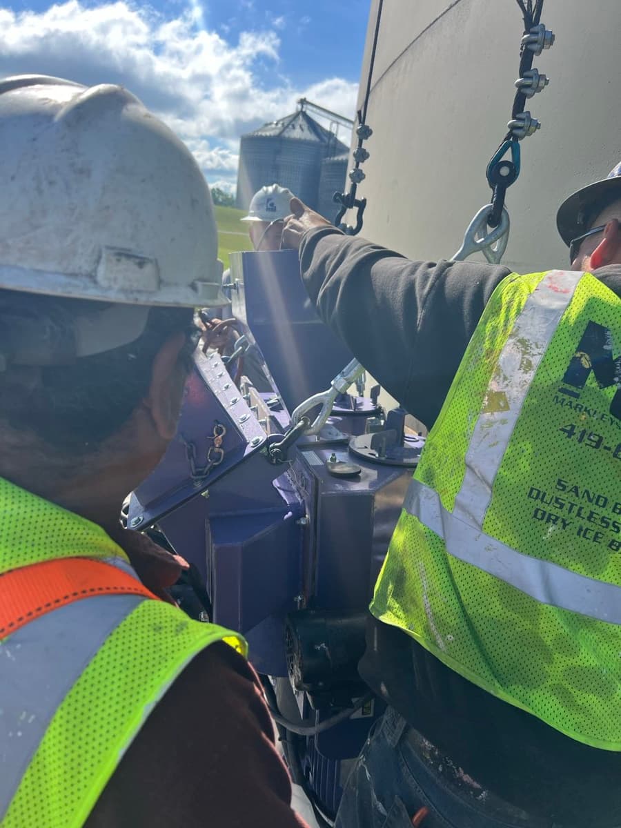 MPC crew member working on top of storage tank