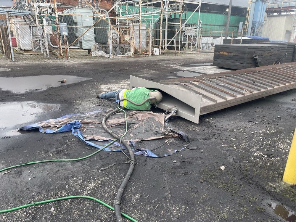 MPC worker sandblasting large steel beams at industrial site