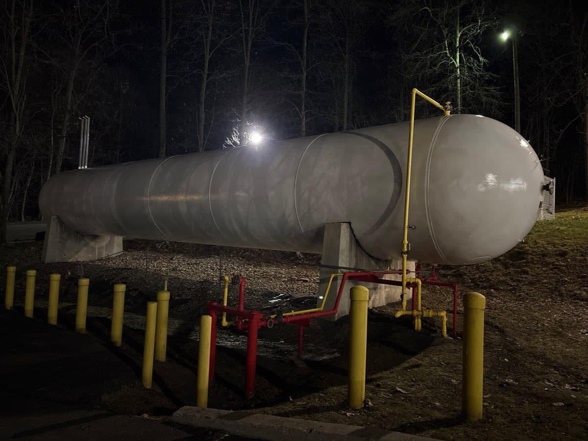 Large propane tank freshly painted, photographed at night